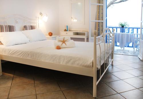 a bedroom with a bed with a white bed frame at Nissiotiko Hotel in Drios