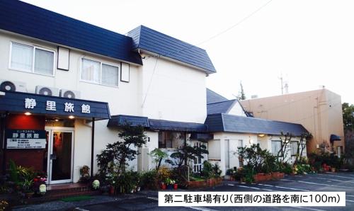 un edificio bianco con scritte su un lato di Business Hotel Shizusato Ryokan a Ogaki