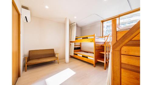 藤沢市にあるTHE GATE HOSTEL SHONAN FUJISAWAの小さな客室で、二段ベッド2台、椅子が備わります。