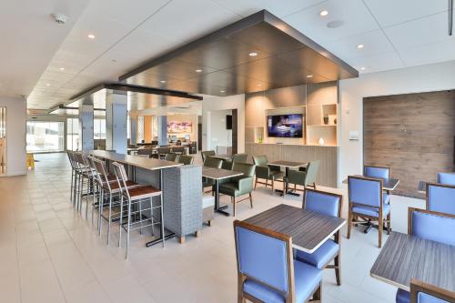 a restaurant with tables and chairs and a bar at Holiday Inn Express & Suites - Nashville MetroCenter Downtown by IHG in Nashville