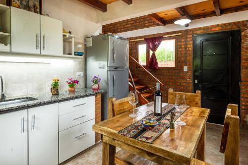 a kitchen with a wooden table and a refrigerator at Las del Tatu in El Bolsón