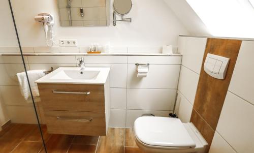 a small bathroom with a toilet and a sink at DUA Hotel in Sarstedt