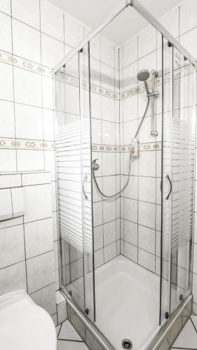 a shower with a glass door in a bathroom at DUA Hotel in Sarstedt