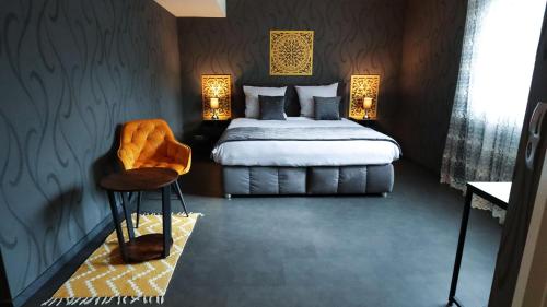 a bedroom with a bed and a chair in it at DUA Hotel in Sarstedt