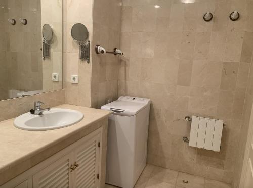 een badkamer met een wastafel, een toilet en een spiegel bij Comodo apartamento en Bahia de la Plata in Zahara de los Atunes