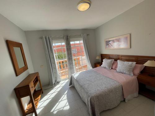 a bedroom with a bed and a large window at Apartamento Gustamar 10 in Caleta De Fuste