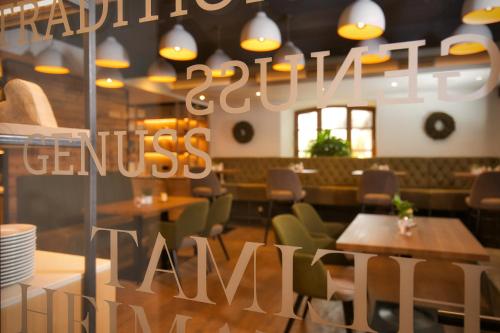 a restaurant with tables and chairs and a sign that reads dining censusarm at Hotel Amberger Hof in Bad Koetzting