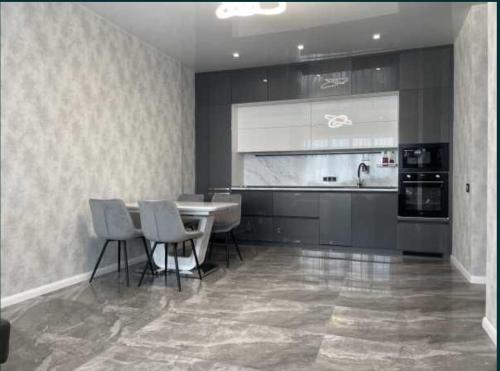 a kitchen with a table and chairs and appliances at Lux 1-bedroom Most City Center area in Dnipro