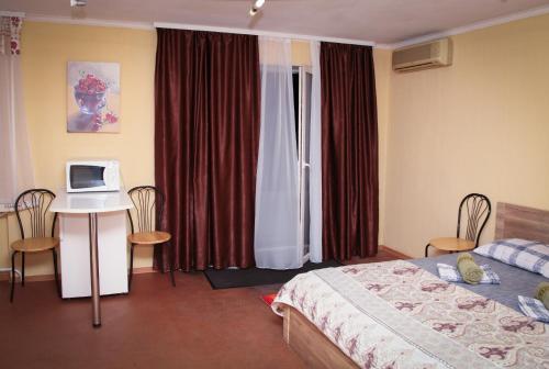ドニプロにあるApartment na Kirova 94のベッド、デスク、コンピュータが備わるホテルルームです。