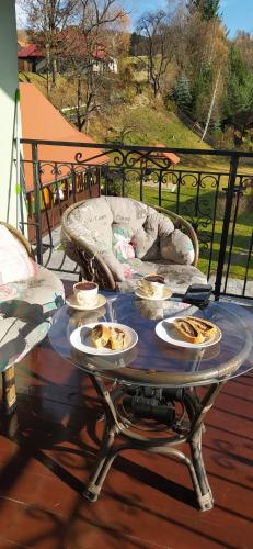 a table with plates of food on a porch at Pod Modrzewiami in Milówka