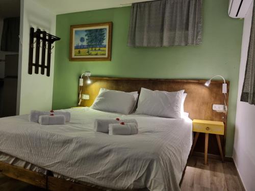 1 dormitorio con 1 cama con 2 almohadas en "פנינת עין כרם" יחידות ורד ואגוז en ‘En Kerem