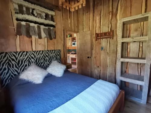 a bedroom with a bed in a wooden cabin at Cabañas Rústicas Pucón Río Trancura in Pucón