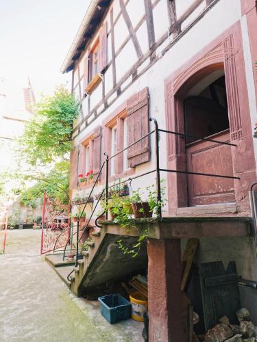 an old building with stairs and a window at Le Haut Relais des Seigneurs - 5 mn Royal Palace de Kirrwiller in Bouxwiller