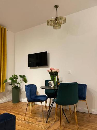 a dining room with a table and blue chairs at Willa 1936 , Parking in Toruń