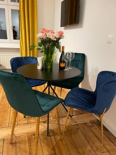 a table with two chairs and a vase with flowers at Willa 1936 , Parking in Toruń