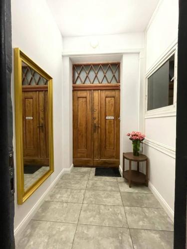 a hallway with two wooden doors and a vase of flowers at Willa 1936 , Parking in Toruń
