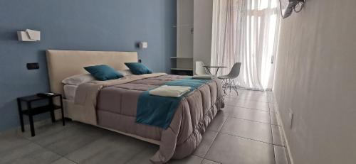 a bedroom with a large bed with blue walls at Hi Relais Rooms in Naples