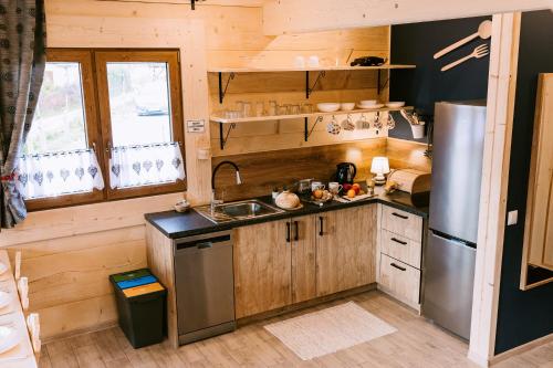 a kitchen with a stainless steel refrigerator and wooden cabinets at Czarna Owca in Kościelisko
