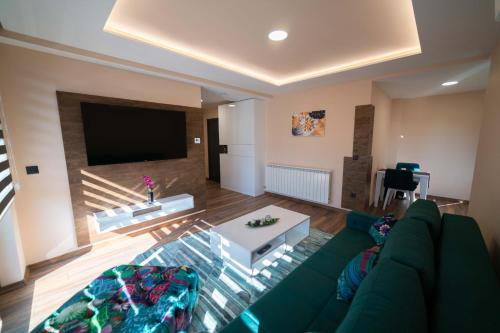 a living room with a couch and a flat screen tv at Luxury Apartments Una Sarajevo in Sarajevo