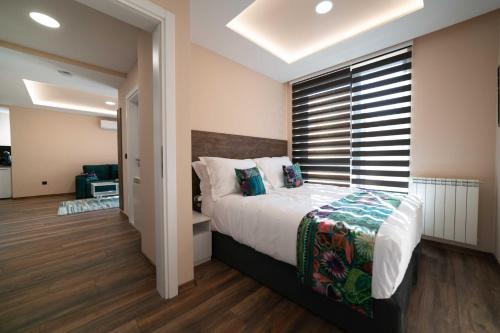 a bedroom with a bed and a large window at Luxury Apartments Una Sarajevo in Sarajevo