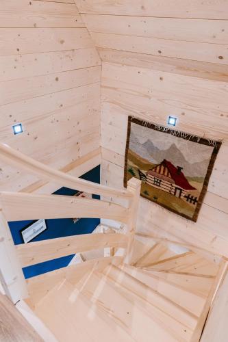 a room in a wooden cabin with a picture on the wall at Czarna Owca in Kościelisko