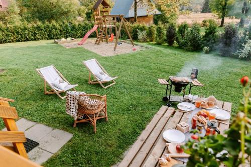a backyard with a table and chairs and a playground at Czarna Owca in Kościelisko