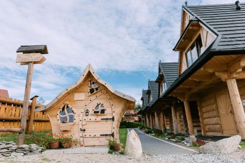a wooden house in the middle of a street at Czarna Owca in Kościelisko