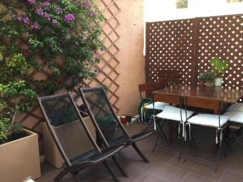 einen Tisch und Stühle auf einer Terrasse mit Blumen in der Unterkunft Chambre 1 personne avec terrasse centre ville Marseille 3 nuits min , femme uniquement in Marseille