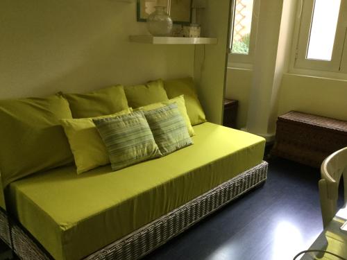 - un canapé jaune avec des oreillers dans le salon dans l'établissement Chambre 1 personne avec terrasse centre ville Marseille 3 nuits min , femme uniquement, à Marseille