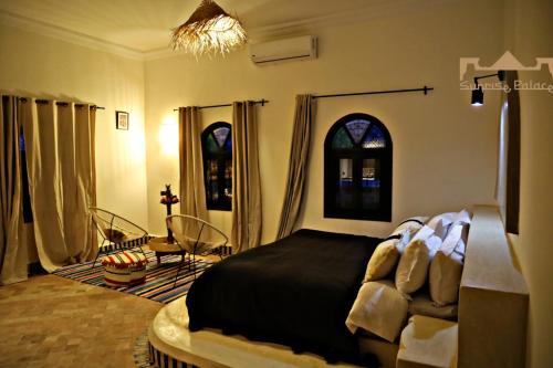 a bedroom with a bed with a black comforter at Sunrise Palace Merzouga in Merzouga