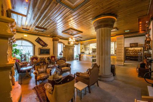una gran sala de estar con una columna y sillas en Kapadokya Hill Hotel & Spa (12+), en Nevşehir