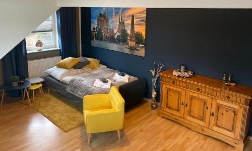 a bedroom with a bed and a yellow chair at Ferienwohnung Am Wäldchen in Erfurt
