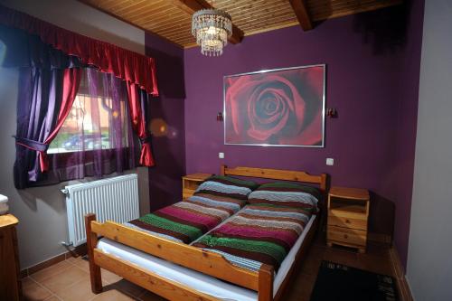 a bedroom with a bed with a purple wall at Wellness Park Pension in Gyenesdiás
