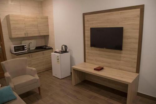 a living room with a television and a table and a chair at فندق فيوري - شارع شهار in Taif