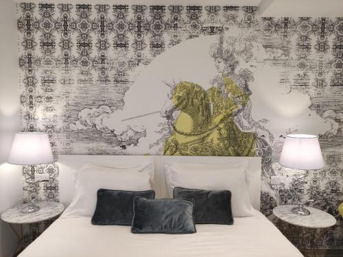 a bedroom with a white bed with two lamps at The G Hotel by JL in St Julian's