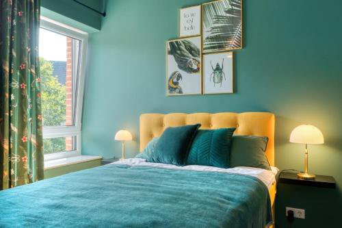 um quarto azul com uma cama e uma janela em One Moment Boardinghouse - Apartment Tropic em Porta Westfalica