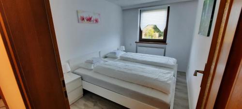 a small bedroom with a bed and a window at Green Hill Apartments - Dornbirn in Dornbirn