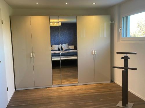 a room with glass doors with a bed in it at Luxusloft mit warmem Outdoor Whirlpool in Mühleberg
