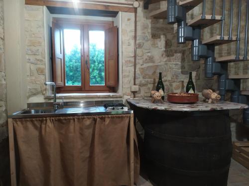 una cucina con bancone, lavandino e finestra di Magione Broccoli a Candelara