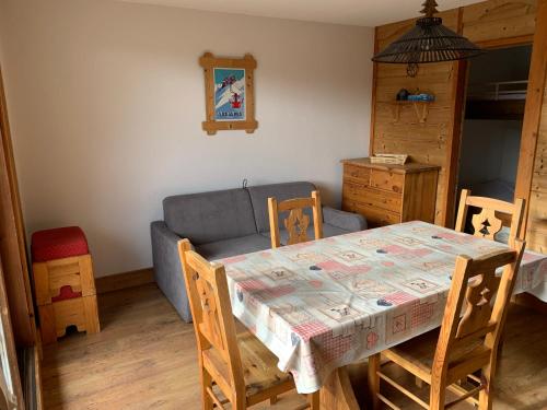 a dining room with a table and a couch at T2 vue piste Résidence Vostok Zodiaque in Le Corbier