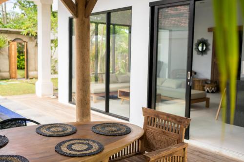 a dining room table with plates on top of it at Mangga Wangga Living in Uluwatu