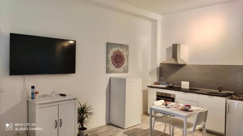 uma cozinha com uma televisão de ecrã plano na parede em CASA SAVENA em Bolonha