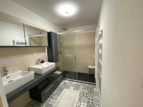 a bathroom with two sinks and a glass shower at Chambre d'hôtes indépendante de Pouzatel proche Bonaguil in Fumel