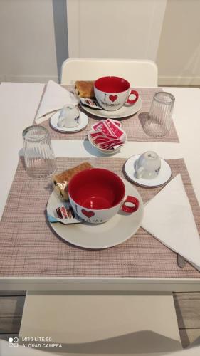 a table with two cups and plates of food at CASA SAVENA in Bologna