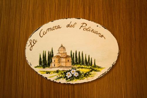 a plate with a building on a wooden wall at Hotel Ristorante Tre Stelle in Montepulciano