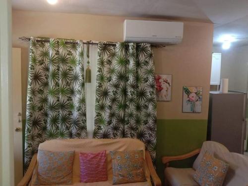 a living room with a curtain and a chair at Laly's B8 cozy Vacation Townhouse - 10km to SBMA in Olongapo