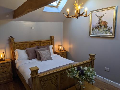 - une chambre avec un lit et un lustre dans l'établissement The Stables - Bankshill, à Lockerbie