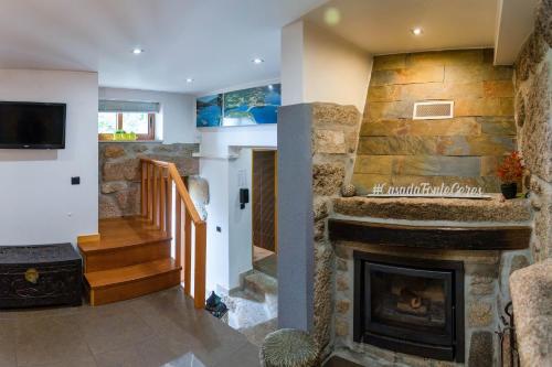 a stone fireplace in a living room with a tv at Casa da Fonte Gerês in Campo do Gerês