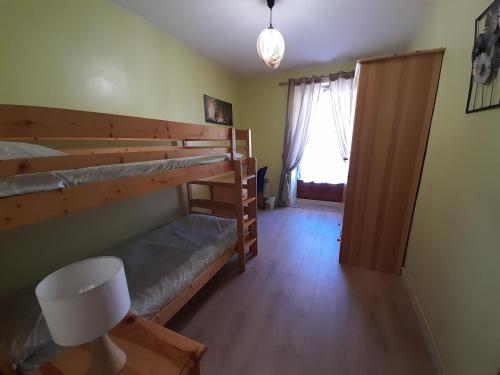 een kamer met twee stapelbedden en een raam bij Chez la malou in La Bresse