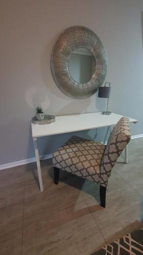 una mesa con una silla y un espejo en la pared en THE SPARE BEDROOM Unit 2 en Harrismith